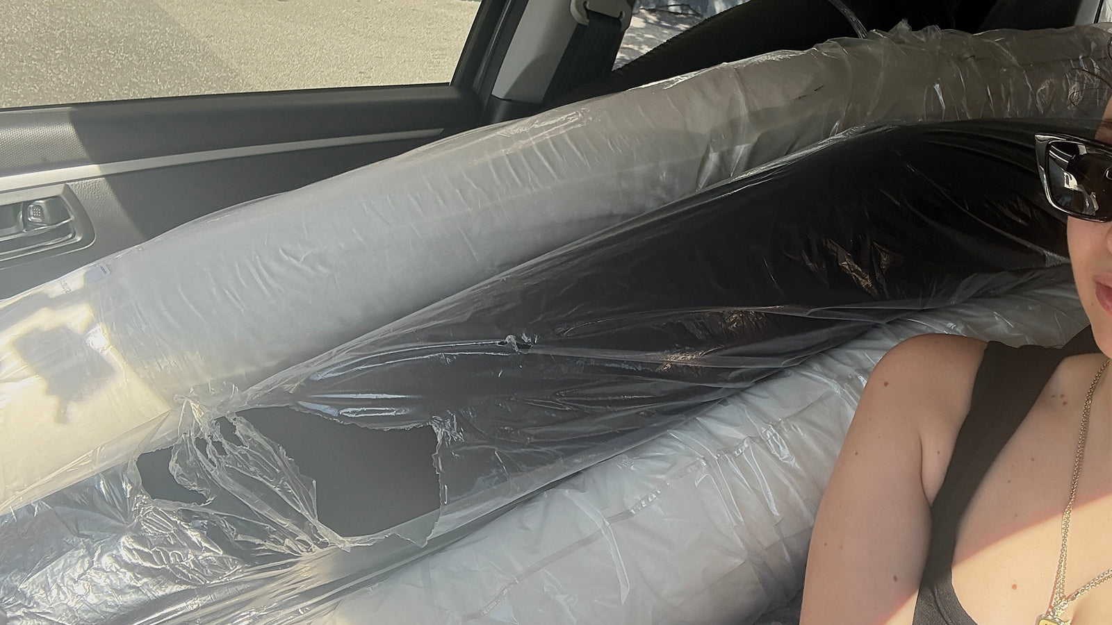 woman in car with rolls of fabric sourced from Japan, Italy and more ready to be made into garments in Australia