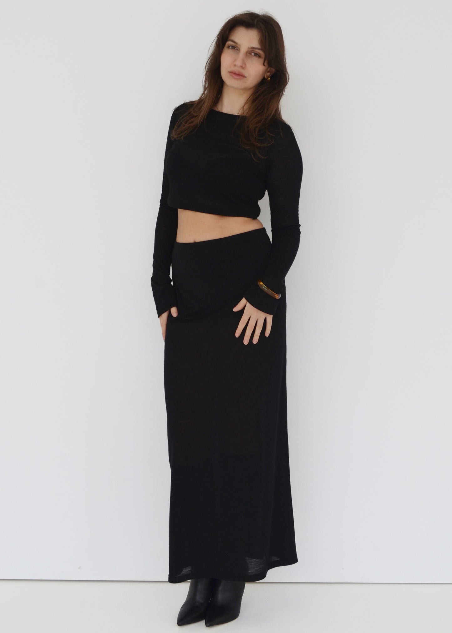 Woman wearing the Isabel maxi skirt mid rise and the matching Tati flared long sleeve crop top in sheer black Japanese Tencel and merino knit. Australian made. 