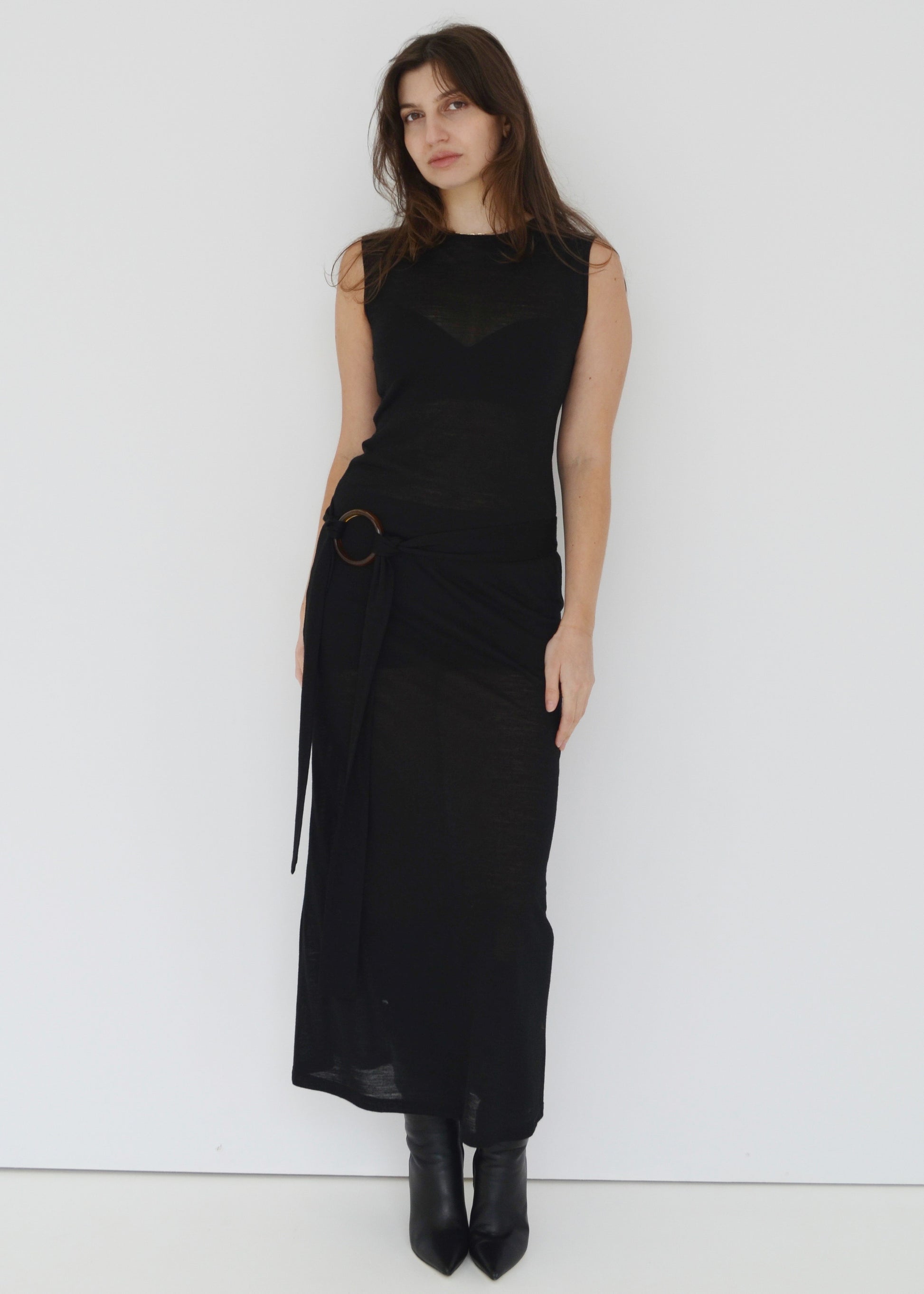Woman wearing a sheer black sleeveless dress against a white background