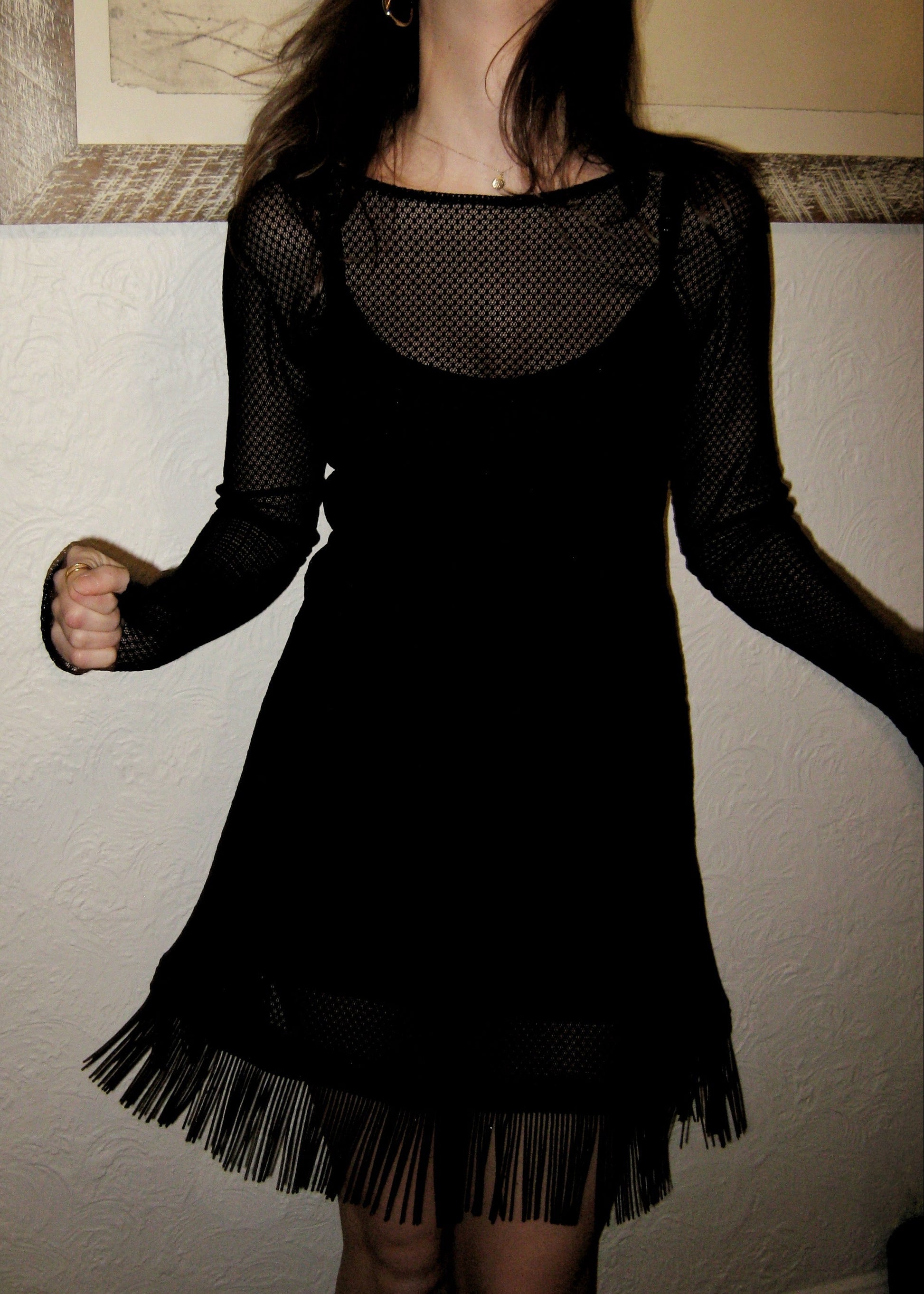 Woman wearing the Kea micro mini dress with fringe edge in black Italian micro floral lace facing forward and showing fringe movement. Made in Australia.