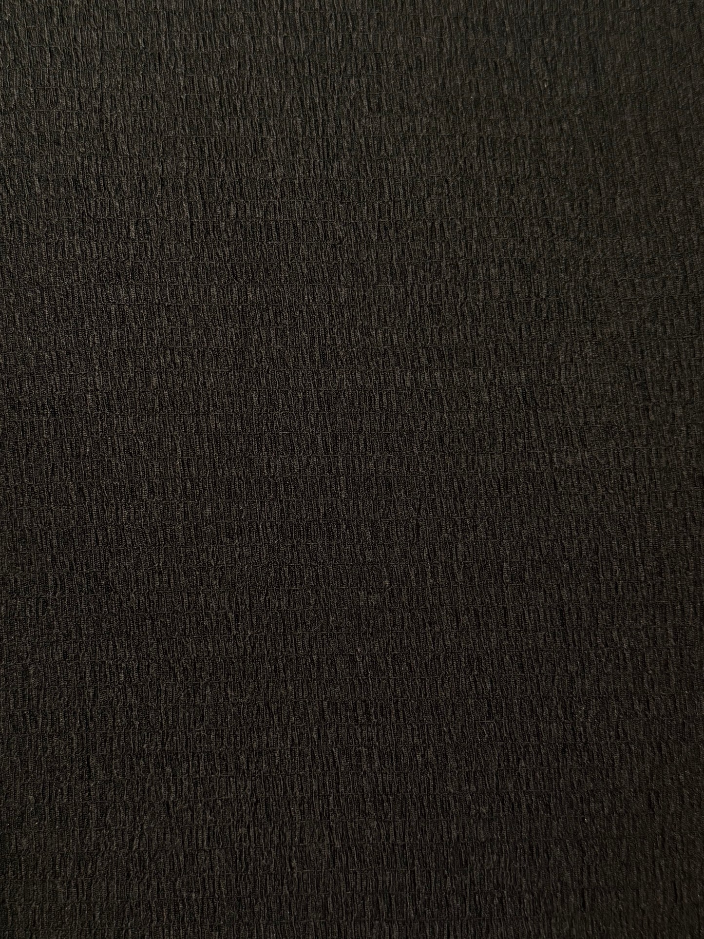 Close up of black crinkle shirred texture. 